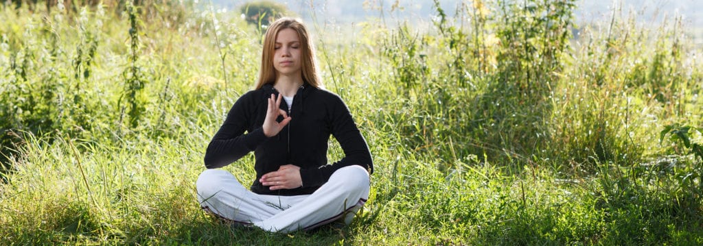chakra meditation - A women practices chakra meditation
